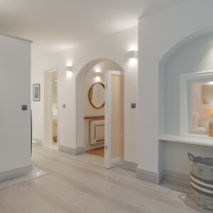 The bright corridor of our two bedroom luxurious apartments in Spetses with modern art on the wall and a glimpse of the twin beds