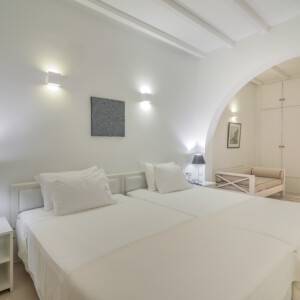 The bed and open space leading into the bathroom at Zoe's Club Double Sea view Room with balcony, Spetses island