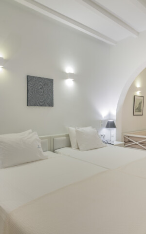The bed and open space leading into the bathroom at Zoe's Club Double Sea view Room with balcony, Spetses island