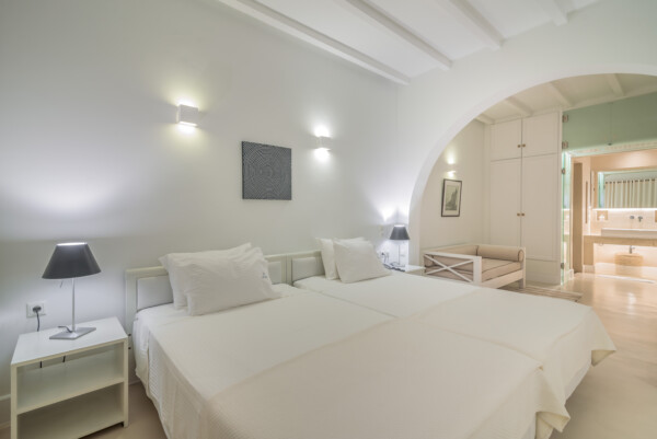 The bed and open space leading into the bathroom at Zoe's Club Double Sea view Room with balcony, Spetses island
