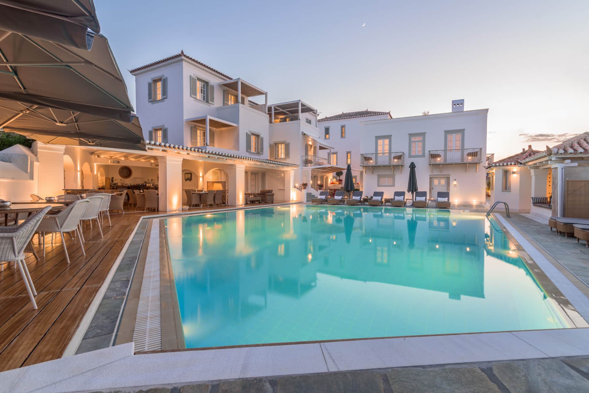 The enchanting ambiance of Zoe's Club Spetses hotel with pool at dusk