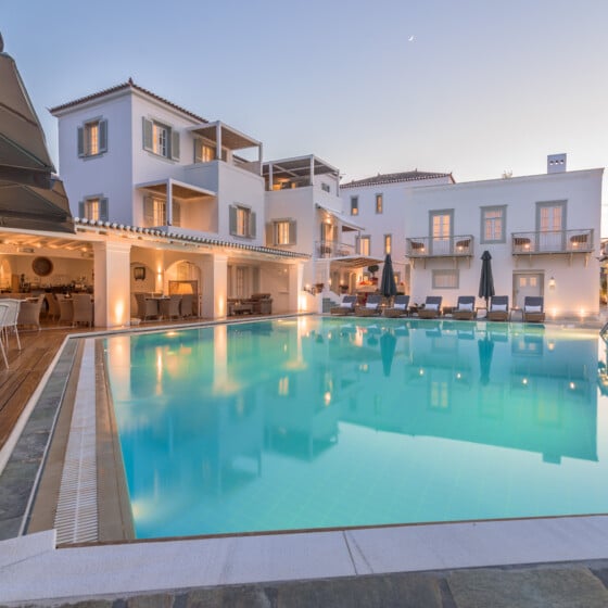 The enchanting ambiance of Zoe's Club Spetses hotel with pool at dusk